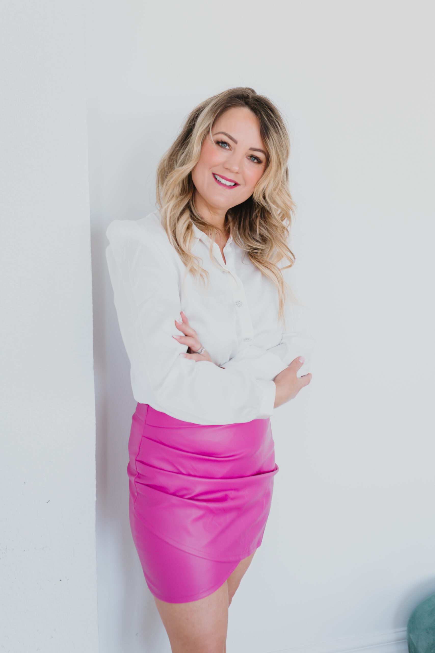 Marla Janzen wearing pink skirt white top arms folded professional